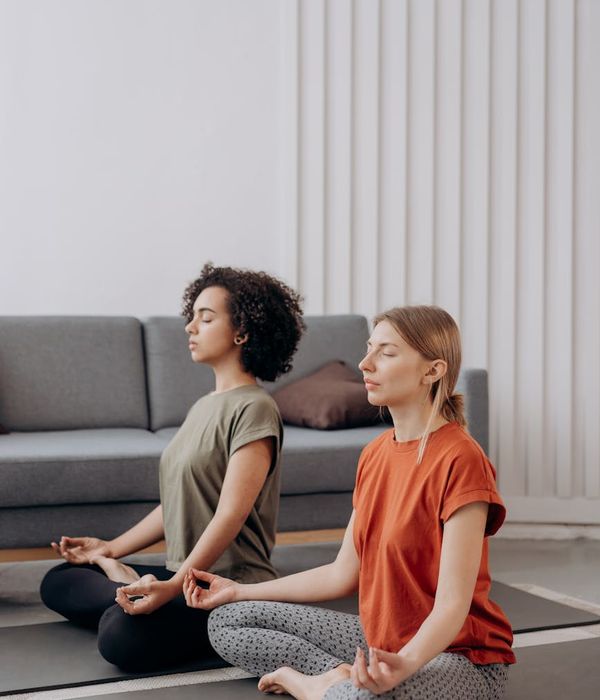Woman in a calm yoga pose in a beautifully lit room.